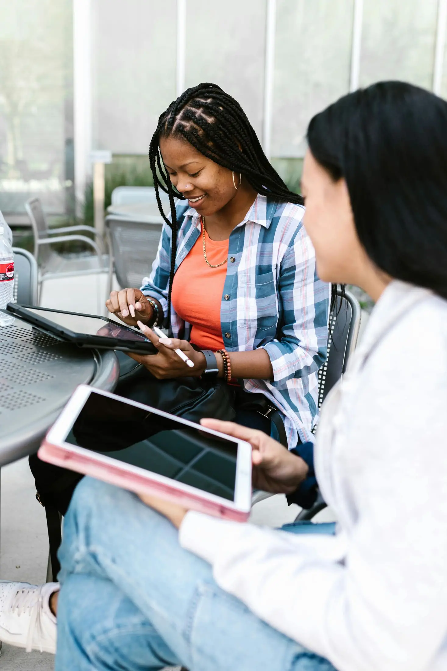 Two people working together with tablets outside